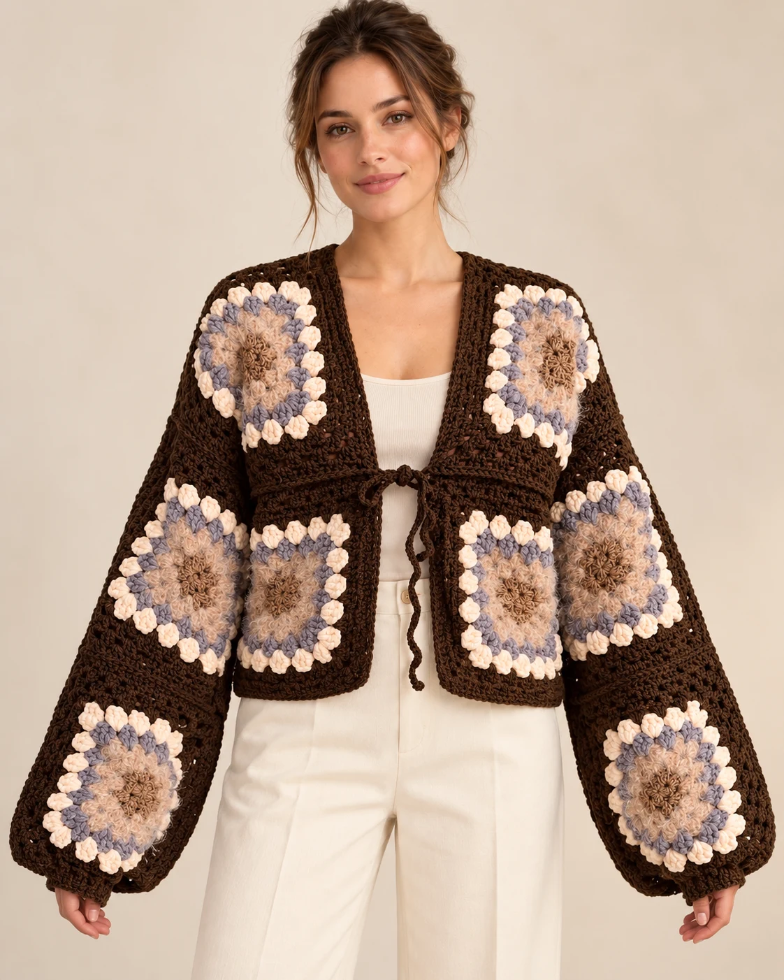 Model wearing the Cocoa Bloom crochet cardigan, front view showing cropped length and voluminous sleeves