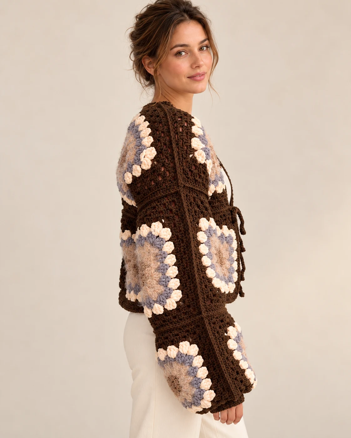 Side view of a model wearing the Cocoa Bloom crochet cardigan, showing sleeve shape and raised floral motifs