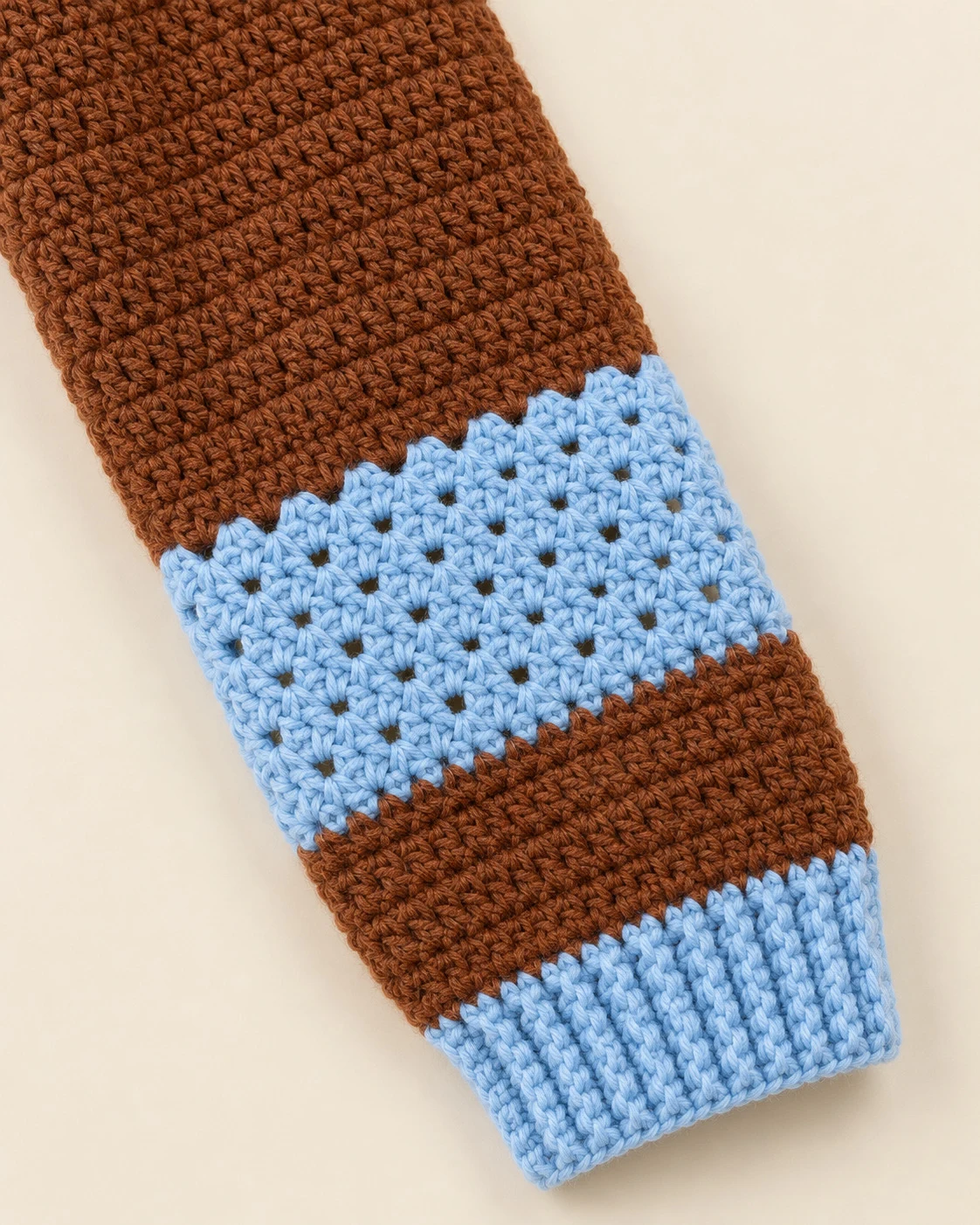 Close-up of the sky-blue openwork sleeve band and ribbed cuff on the Chestnut & Sky Crochet Cardigan