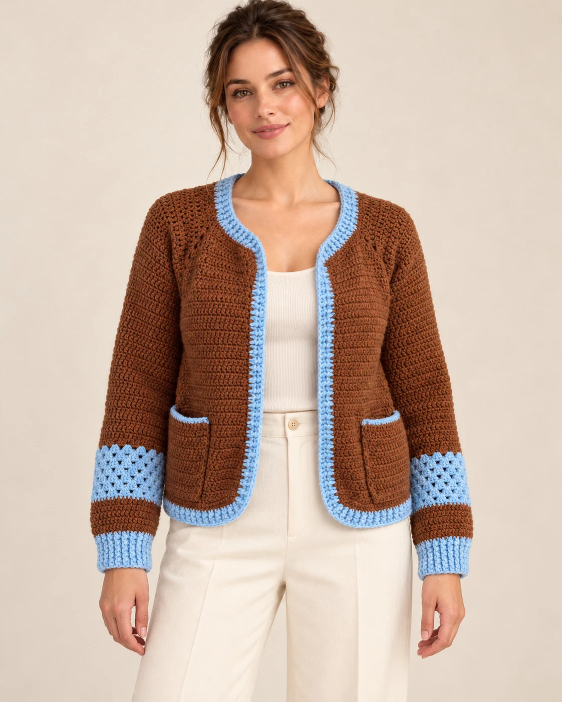 Model wearing the Chestnut & Sky Crochet Cardigan from the front with cream trousers